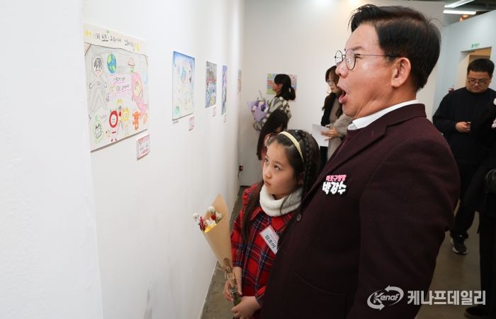 박강수 마포구청장이 수상 어린이와 함께 전시된 그림을 살펴보고 있다.